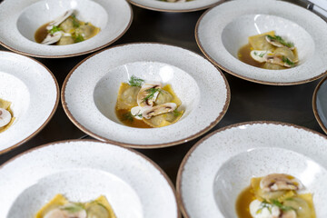 Dumplings, dumplings, with egg and decorated with champignons, dill. Plates stand in the restaurant.