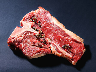 raw porterhouse beef steak on a black background