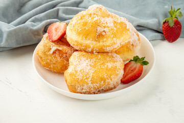 Classic dessert malasada. Donuts Portuguese in a white plate on a white background.