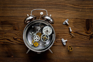 Broken alarm clock top view. Watch mechanism and watchmaker tools