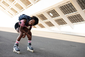 Beautiful African woman with roller skates. Urban sexy girl enjoy outdoors