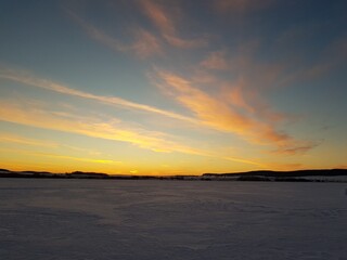 Fototapeta na wymiar Yellow clouds over the snowy field