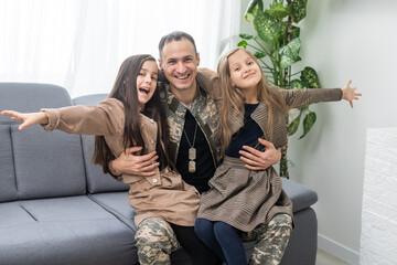 military father and two daughters at home