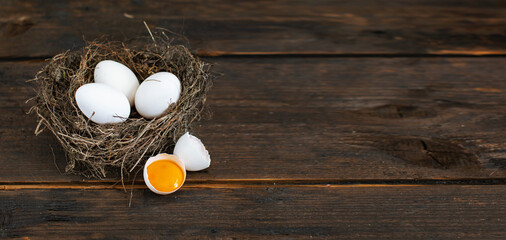 Świeże jajka z wolnego wybiegu w gnieździe na rustykalnym tle deski - obrazy, fototapety, plakaty
