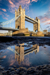 Low angle view of the iconic Tower Bridge in London. England, during sunrise with reflections in a...