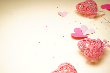 Fototapeta premium Pink hearts and confetti for Valentine's Day on yellow background, close up.