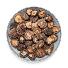 Dried shiitake mushrooms in a plate isolated on white background. Top view, flat lay. Asian vegetarian food concept.