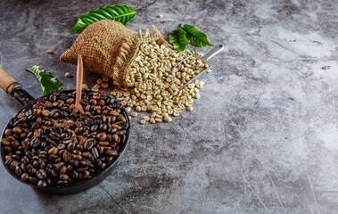 Raw green unroasted coffee beans in brown sacks and roasted coffee beans in a pan.