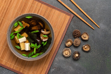 Japanese vegetarian miso soup with shiitake mushrooms, tofu cheese, seaweed and green onions in a...
