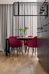 Stylish composition of elegant dining room interior design with velvet chairs, design wooden table, lamps, chimney and beautiful personal accessories. Modern home decor. Template.