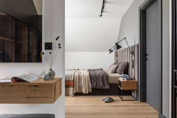 Minimalistic composition of bedroom interior with velvet bed, shelf, design lamp, shelf and elegant...
