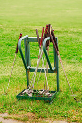 golf clubs in a stand on the lawn. accessories for the game.