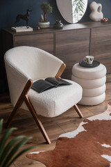 Elegant modern living room interior design with fluffy armchair, pouf, wooden commode and modern...
