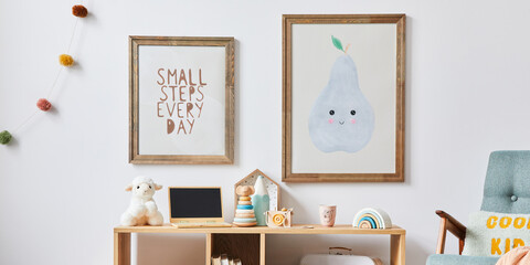 Cozy interior of child room with mint armchair, brown mock up poster frame, toys, teddy bear, dolls, plush animal, decoration. White wall. Warm kid space. Template.