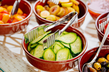 bowls with chopped vegetables and fruits on the table. 