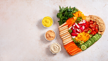 Colorful vegan Charcuterie board with raw vegetables and whole wheat snacks