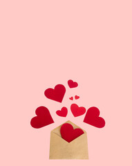Red paper hearts spill out of a craft envelope on a pink background mockup postcard blank designer