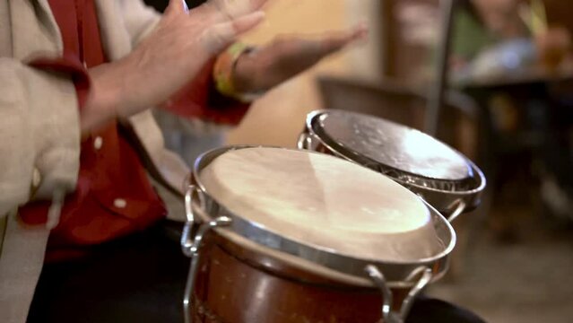 Person playing bongo drums at night