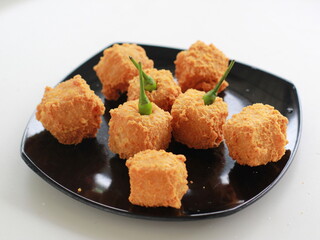 Photo of crispy tofu and green chili on a black plate