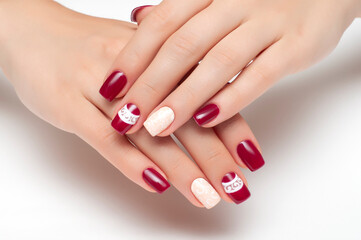 Burgundy, beige manicure with white monograms on short square nails close-up on a white background. Gel manicure.