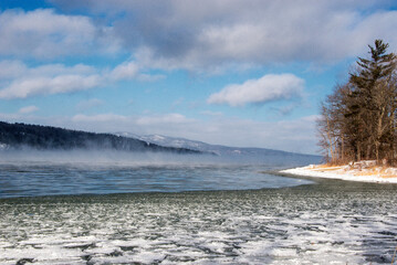 Winter scene with a lake and ice steam