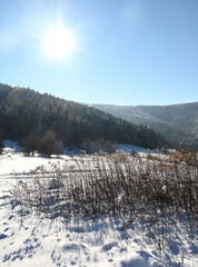 Górska dolina oświetlona zimowym słońcem.