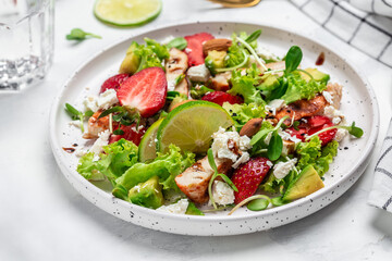Summer fruit strawberry salad with chicken meat avocado, feta cheese, lettuce and nuts balsamic vinegar, concepts health food