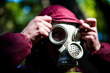 Ecological catastrophy. Post apocalyptic survivor in gas mask. Man at forest.