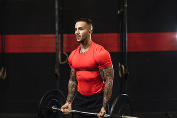 Chico joven musculado y tatuado realizando deporte 