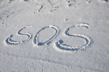 The inscription on the snow. Letters written in the snow. SOS, calling for help