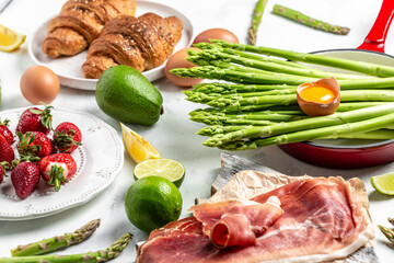 Ingredients for a hearty breakfast, Ketogenic diet meal Poached egg with asparagus spears and prosciutto. banner, menu recipe place for text, top view