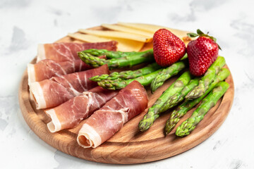 Antipasto platter. asparagus, jamon, ham, prosciutto, strawberries. ketogenic diet lunch concept. Keto Paleo diet menu, top view