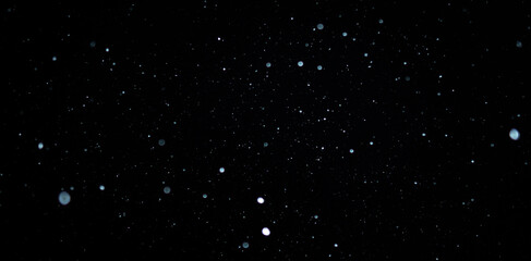 Blurred snowflakes on a dark background. Overlay image for snowfall effect