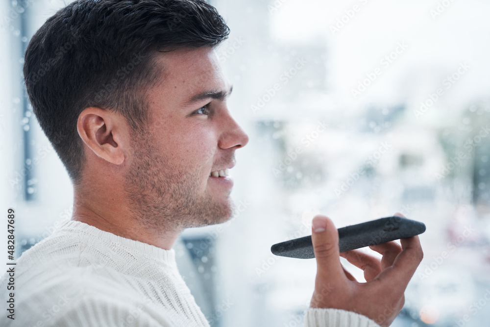 Poster Staying connected at a safe distance. Shot of a young man using a smartphone while working from home.