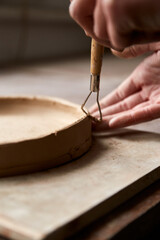 Female ceramist working in pottery studio. Ceramist's Hands Dirty Of Clay. Process of creating pottery. Master ceramist works in her studio