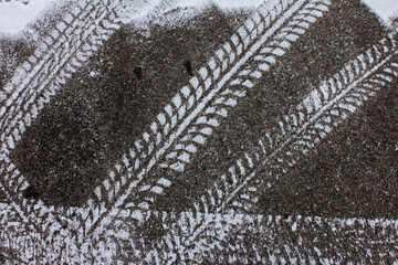 Abstrakt - Reifenspuren durch weißen Schnee auf der Fahrbahn im WInter