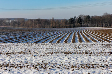  Struktur durch Furchen mit Schnee auf dem Feld im Winter