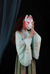 Woman wearing kimono, hanfu and a fox mask. Japanese, chinese traditional concept. Kitsune