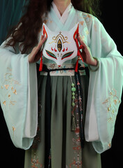 Woman wearing kimono, hanfu and a fox mask. Japanese, chinese traditional concept. Kitsune