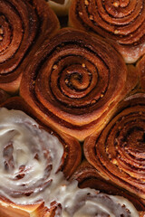 Freshly baked homemade cinnamon rolls or cinnabon on a baking sheet. Cinnabons traditional dessert buns pastry made swirl. Top view.