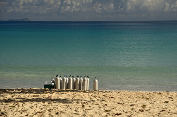 An einem Tropischen Strand stehen vor dem klaren Wasser des Ozeans aufgereihte Sauerstoff Flaschen...