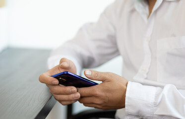 Business man using a mobile phone on the desk in the office.