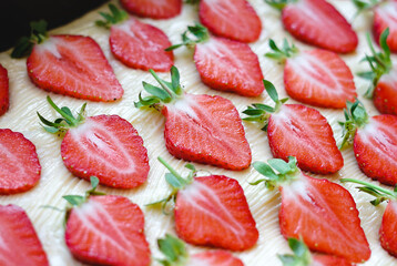Many sliced strawberries on a light background