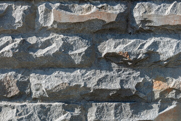 A gray stone wall made of rough stones. 