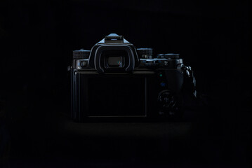 DSLR, Mirrorless camera in low key light with a black background and a moody light, still life...