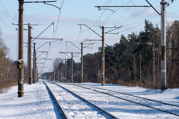 Two branches of the electrified railroad stretching into the distance. Electric poles along the...