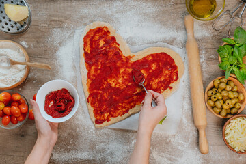 Woman covered homemade pizza with tomato paste