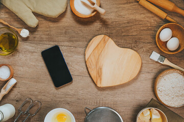 Heart shape wooden board near ingridients for prepairing dough