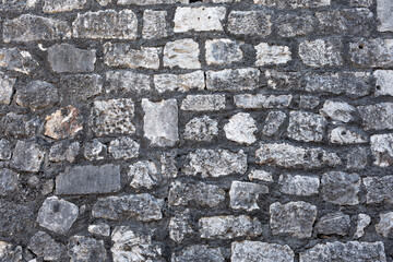 Old grungy retro dirty faded brick wall of ancient city. Uneven pitted peeled surface brickwork of cellar worn. Ruined shabby stiff blocks.Hard solid messy ragged holes brickwall of 3D grunge design.