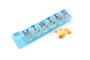 Daily portion of vitamins, drug medicines, tablets, dietary supplements in pill organizer or plactic pill box. A weekly container of tablets, vitamins. Nutritional supplements